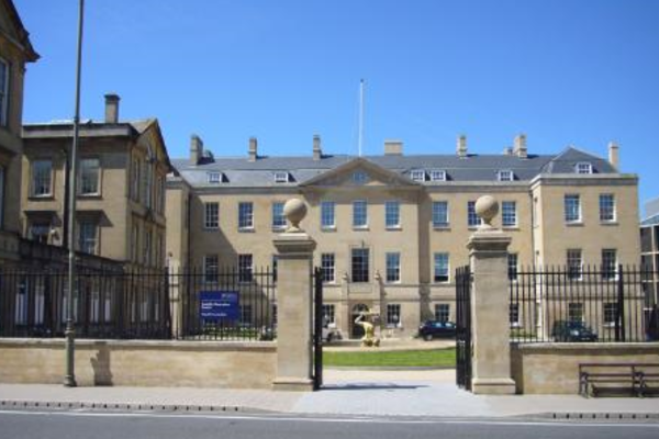 Photo of the exterior of the Radcliffe Humanities building against a bright blue sky